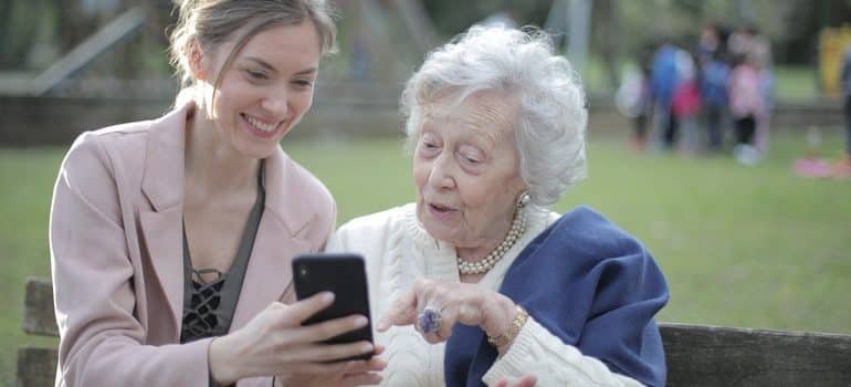 An elderly woman on a bench with her daughter