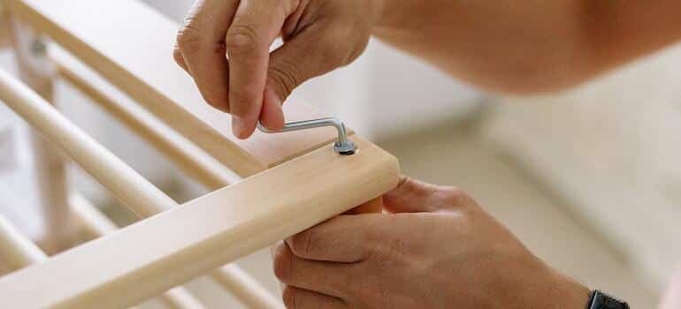 A person disassembling furniture