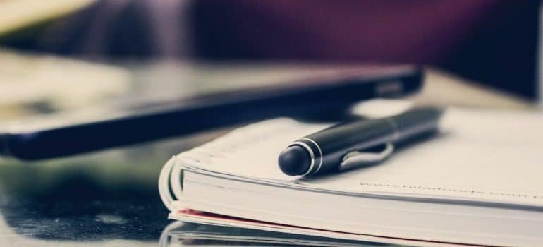 A notebook with a pen on it, as you're going to need to write down a lot of lists and otherwise make plans while coordinating your office relocation to York.
