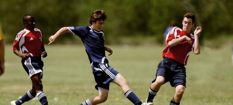 Three men playing soccer