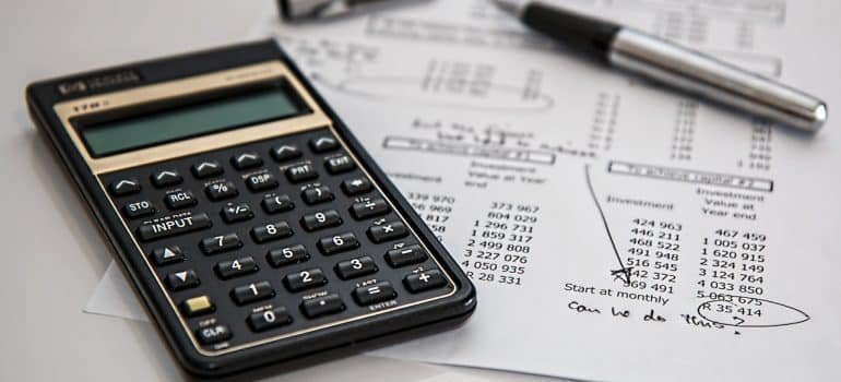 A calculator and a paper showcasing budgeting planning.