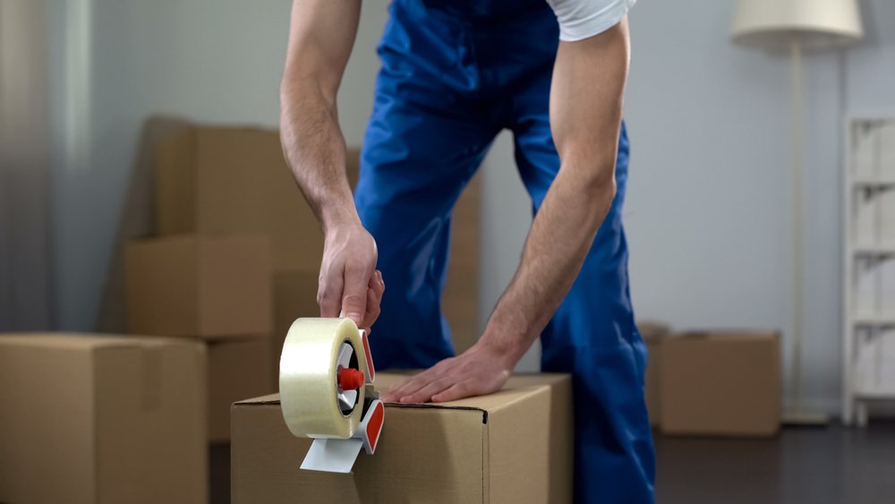 worker-putitng-tape-on-boxes-to-keep-them-closed